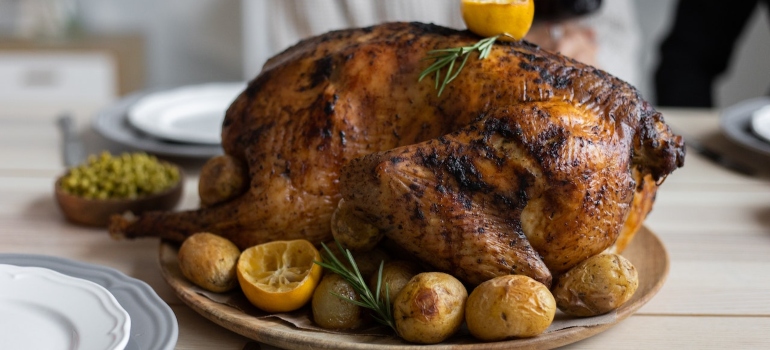 A baked turkey with potatoes and lemon.