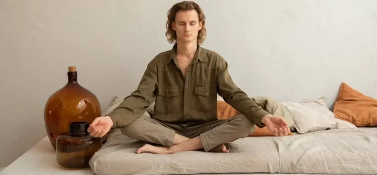 A man meditating while sitting on the ground