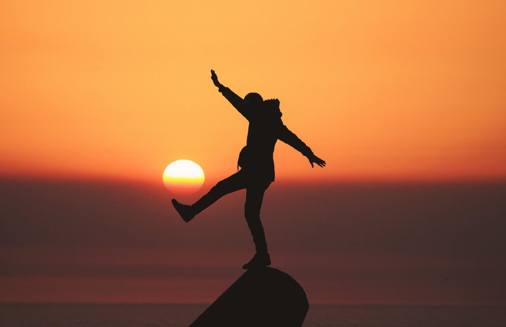 Person standing on a rock during sunset after leaving Lantana detox